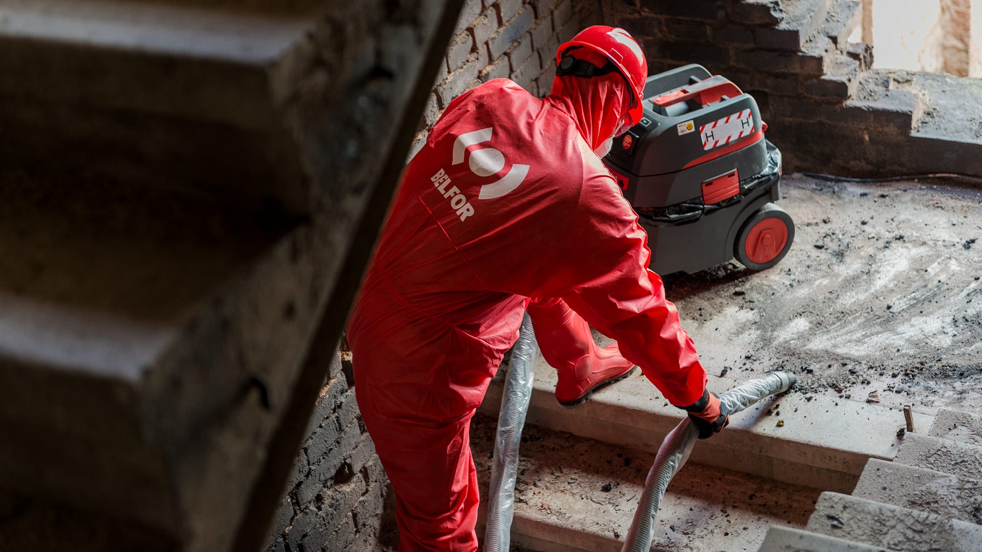 Ein BELFOR-Mitarbeiter beim Staubsaugen von Schutt