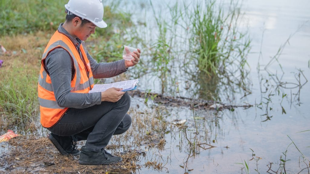 Un ouvrier inspecte un échantillon de la masse d'eau