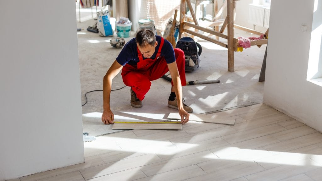 Un homme prépare un plancher en bois