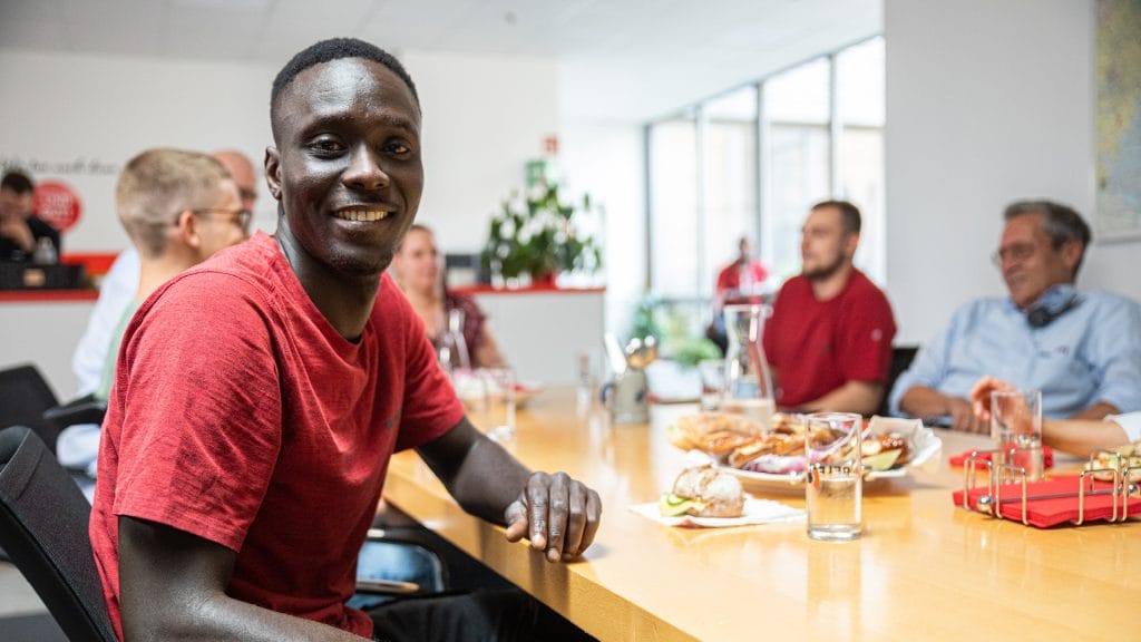 Un employé masculin souriant lors d'un déjeuner au bureau