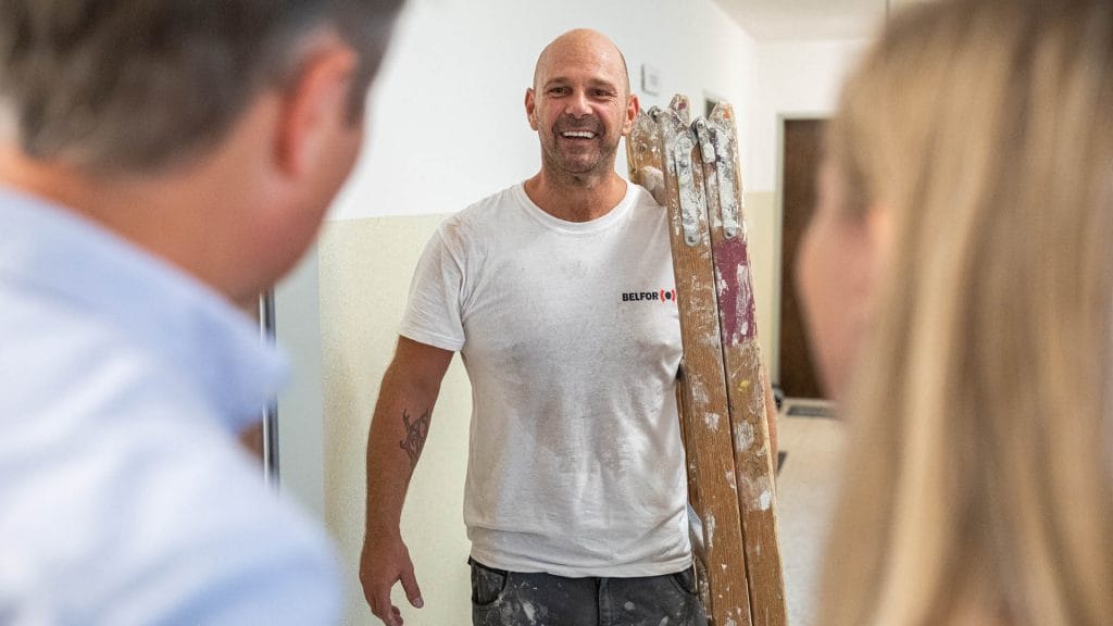 A BELFOR employee carrying a ladder