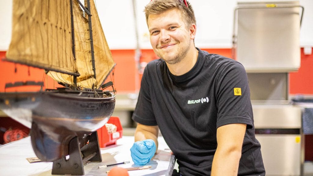 A BELFOR employee wearing a black shirt and smiling