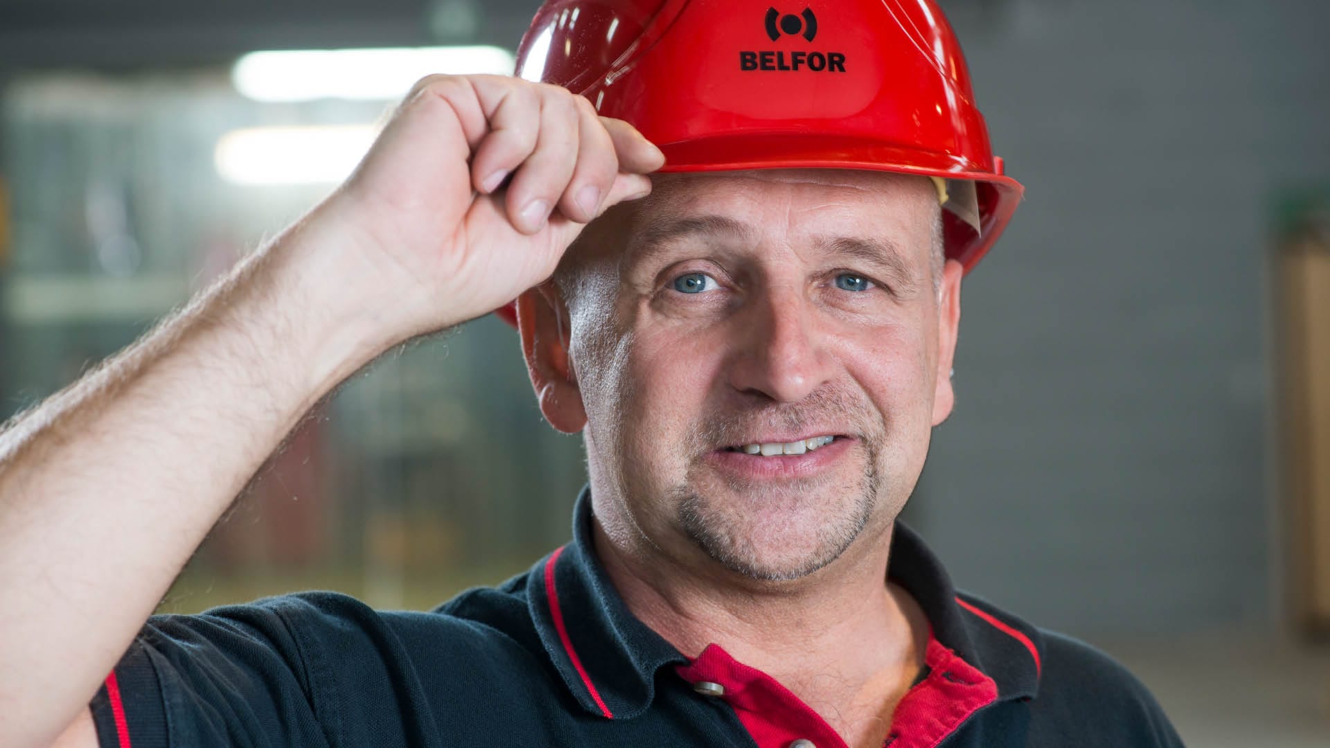 A BELFOR employee with a hard hat and the BELFOR logo