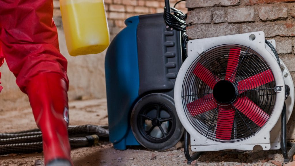 A close up image of an exhaust fan and an employee working