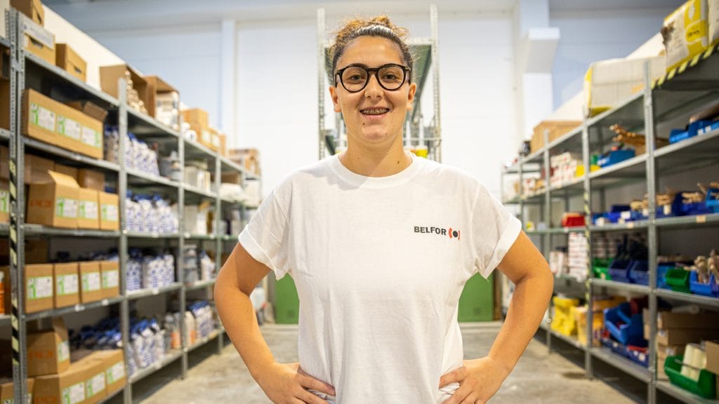 A female BELFOR employee smiling in a warehouse