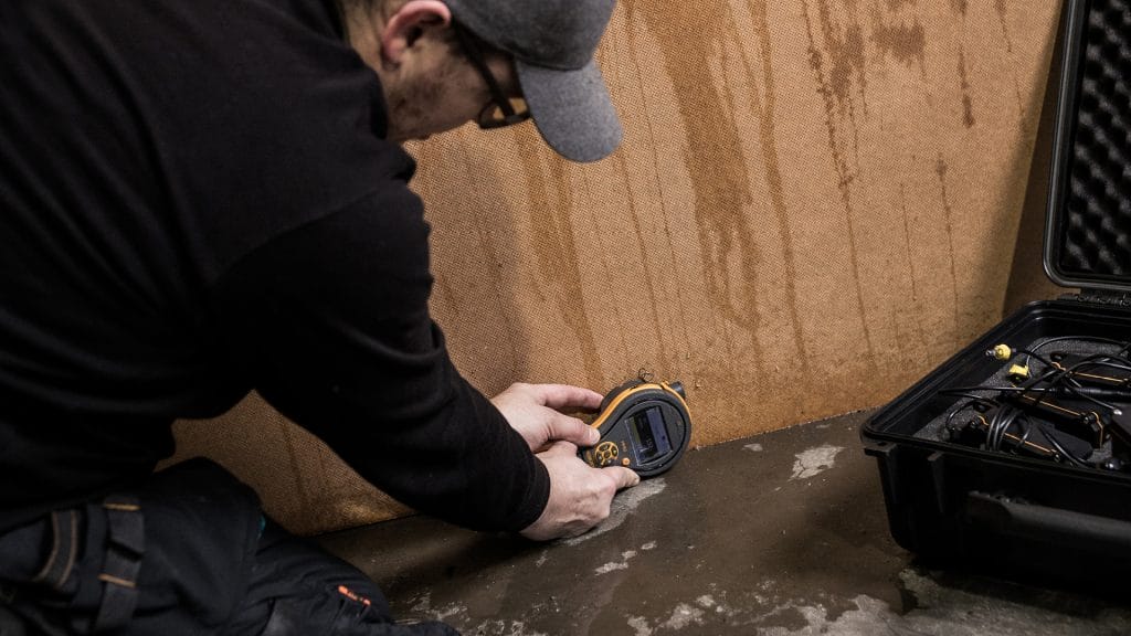 A male employee evaluating a wet wall