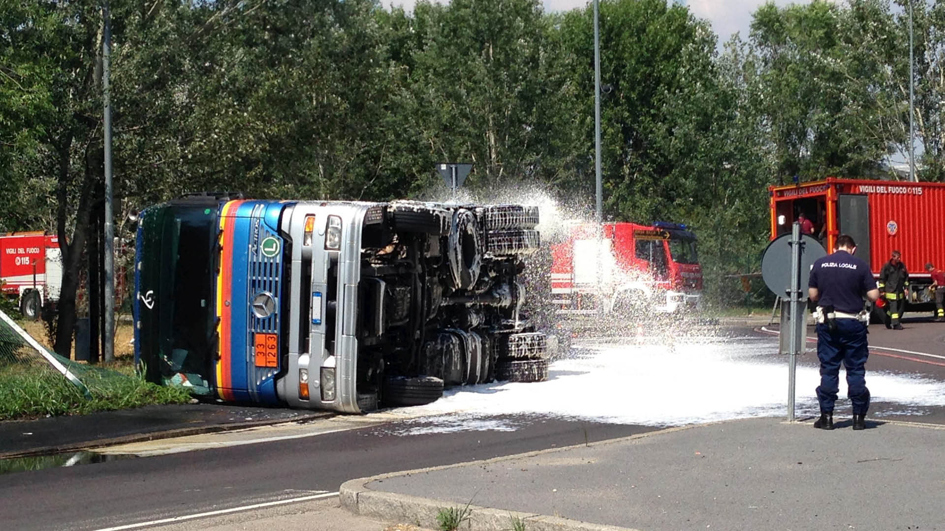 A truck lying on its side which is being extinguished