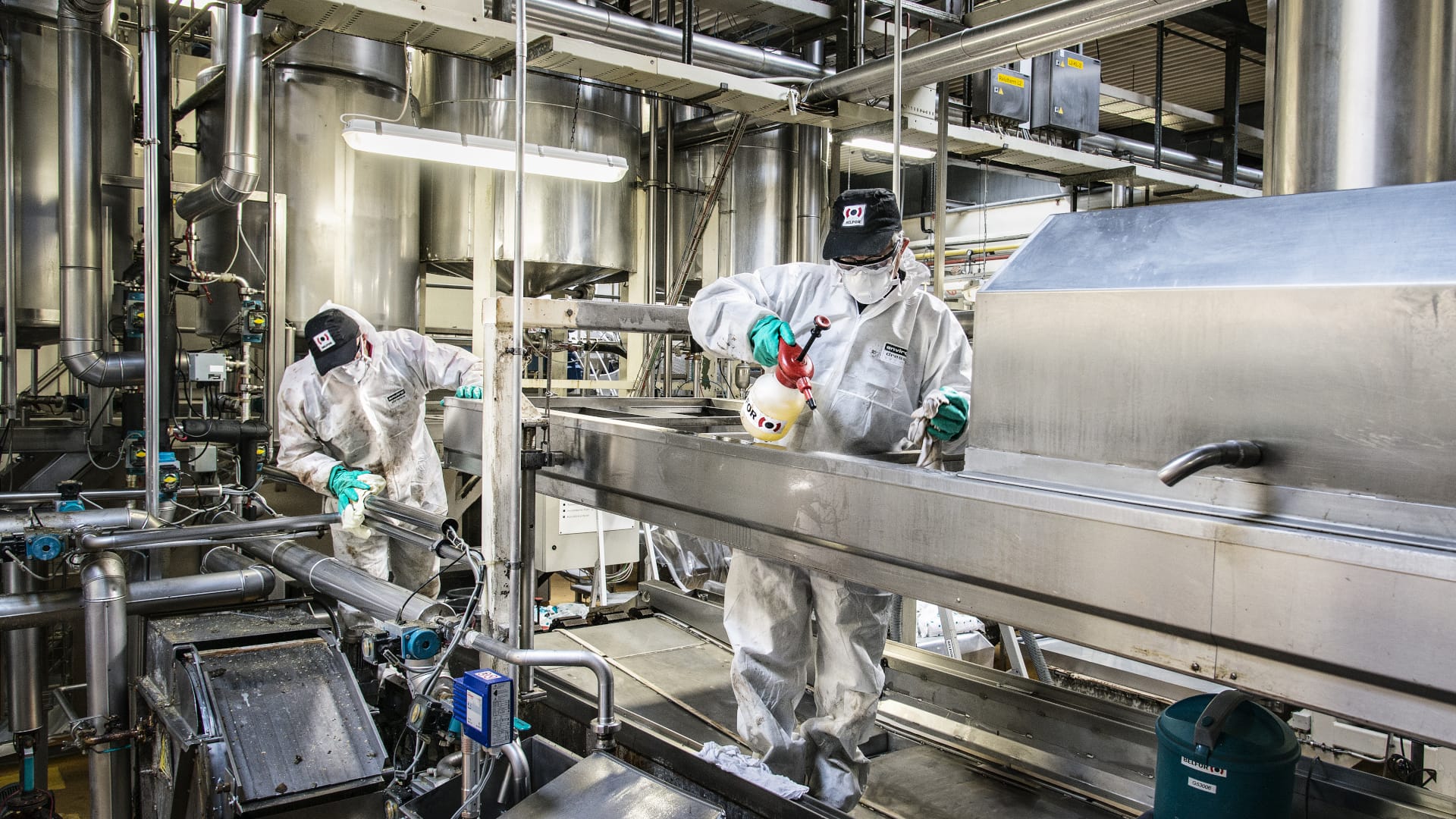 Two BELFOR employees cleaning a machine