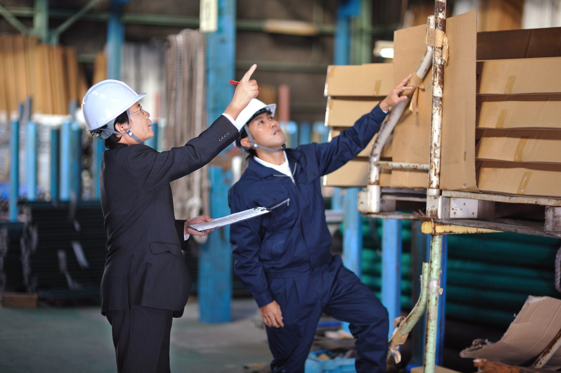 Two people with hard hats in a warehouse