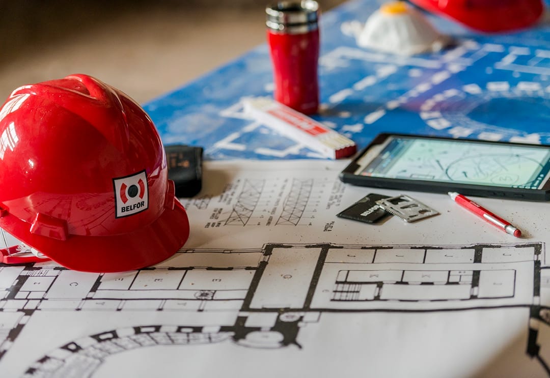 A BELFOR hard hat and blueprint on the table_White-modul_1080x743px