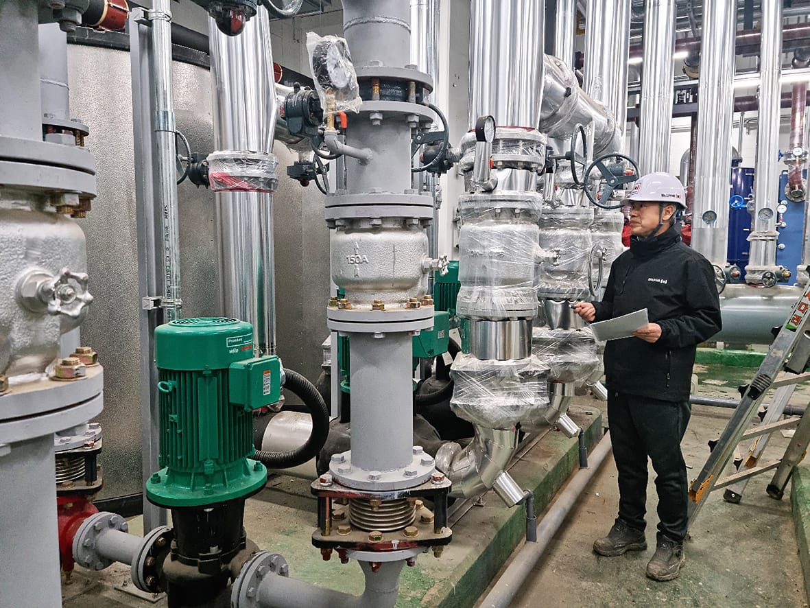 A MALE BELFOR employee inspecting the industrial pipes for any damages.