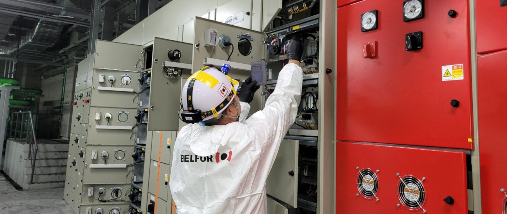 A BELFOR employee working on a switchboard