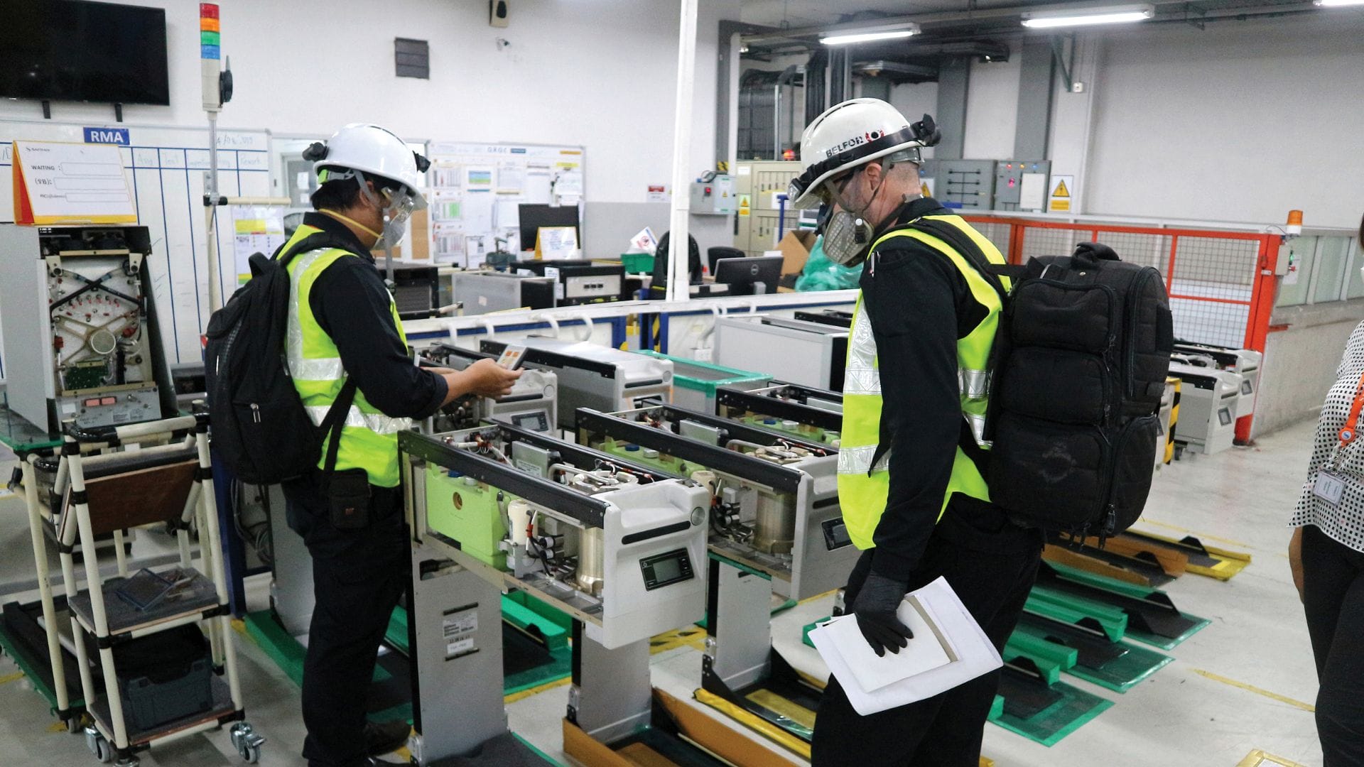 BELFOR empoyees with helmets inspecting a machine