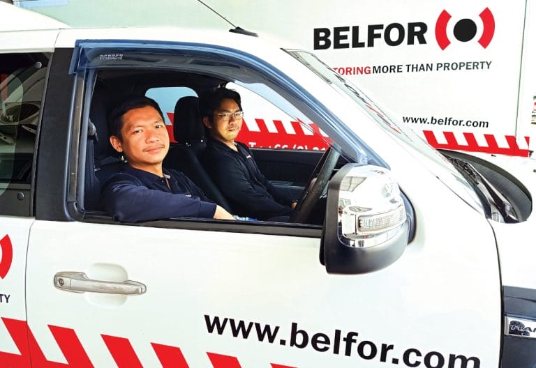 Two BELFOR male BELFOR employees sitting in a BELFOR car