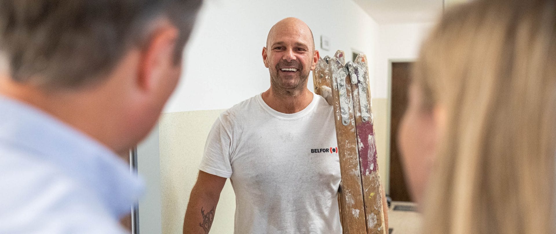 A BELFOR employee carrying a ladder