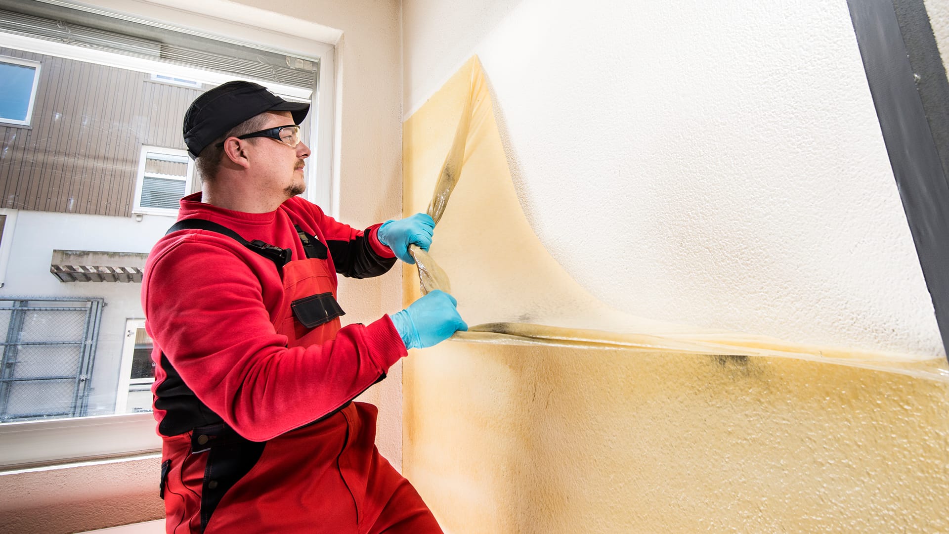 A BELFOR employee peeling off the Soot Removal Film