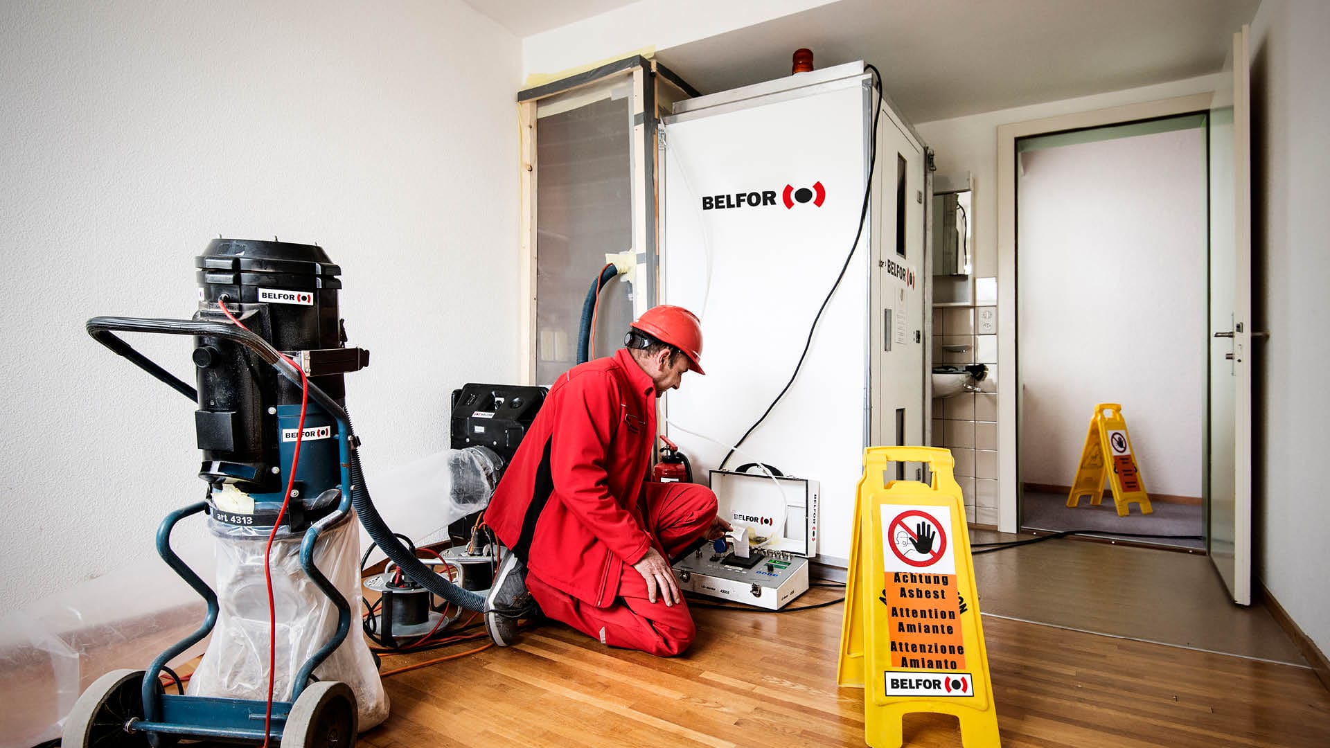 A BELFOR employee works in a hotel room