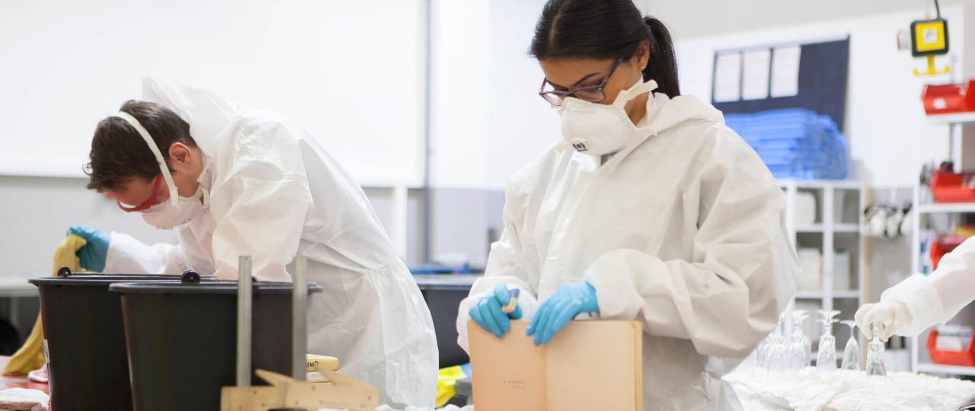 An employee wearing PEE to prevent inhaling hazardous materials