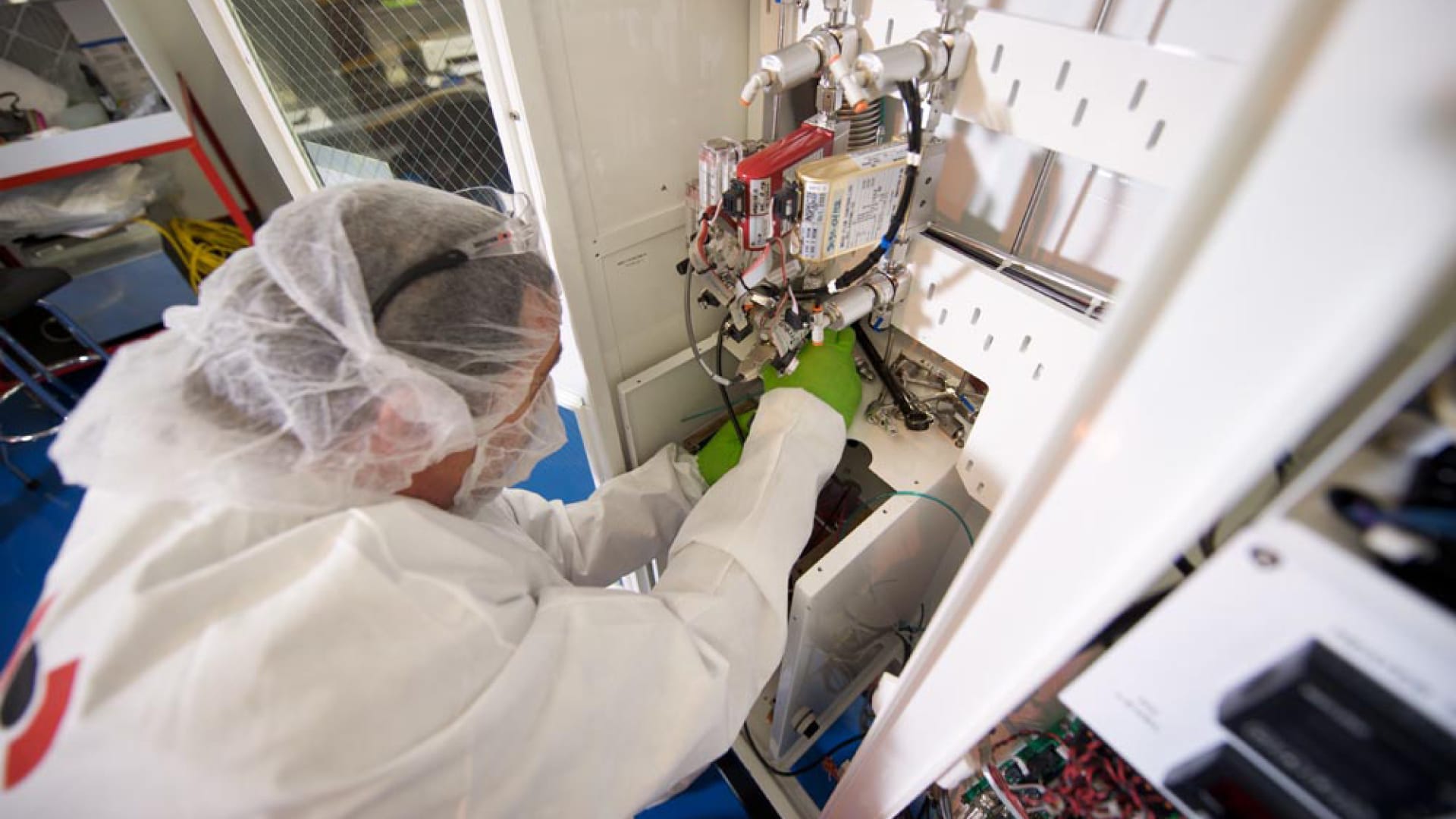 BELFOR employee in white protective suit cleaning electronic parts