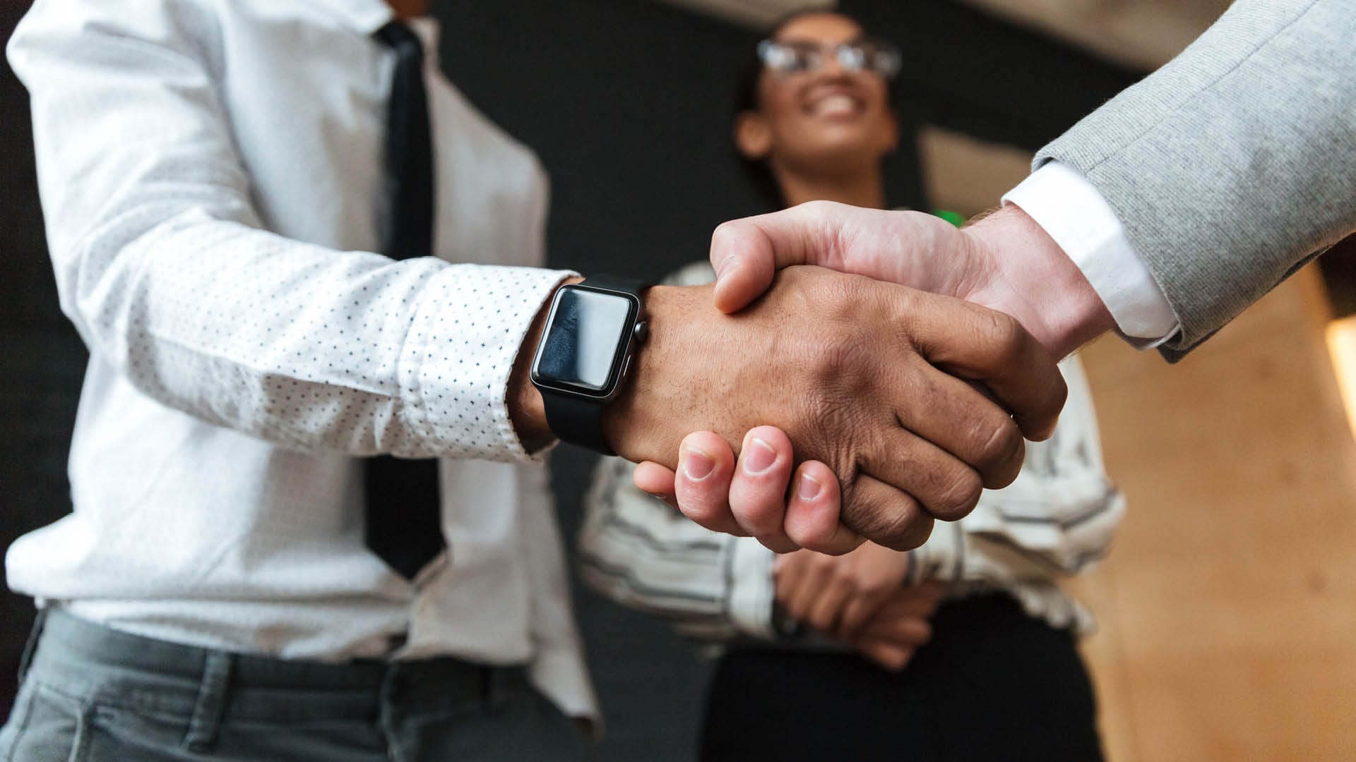 Two men shaking their hands over a deal