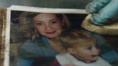 BELFOR Commercial - Fire - Close up of a BELFOR worker cleaning a family photo of smoke damage