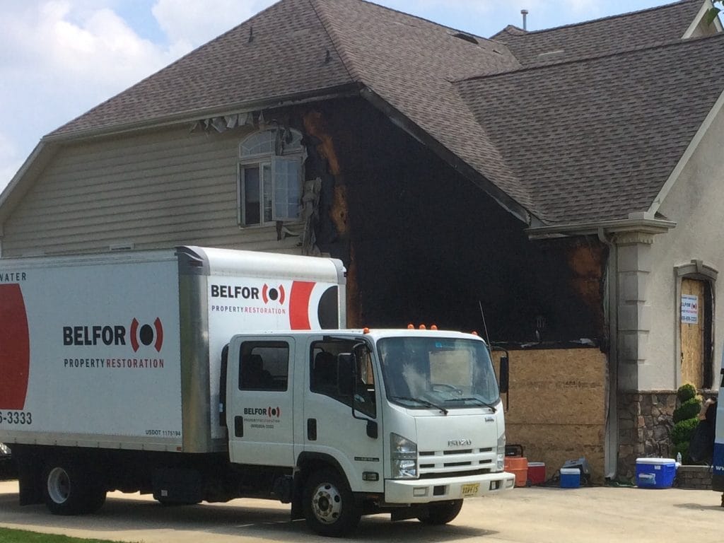 A BELFOR truck in front of a property