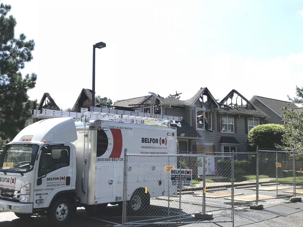 A BELFOR truck in front of a property