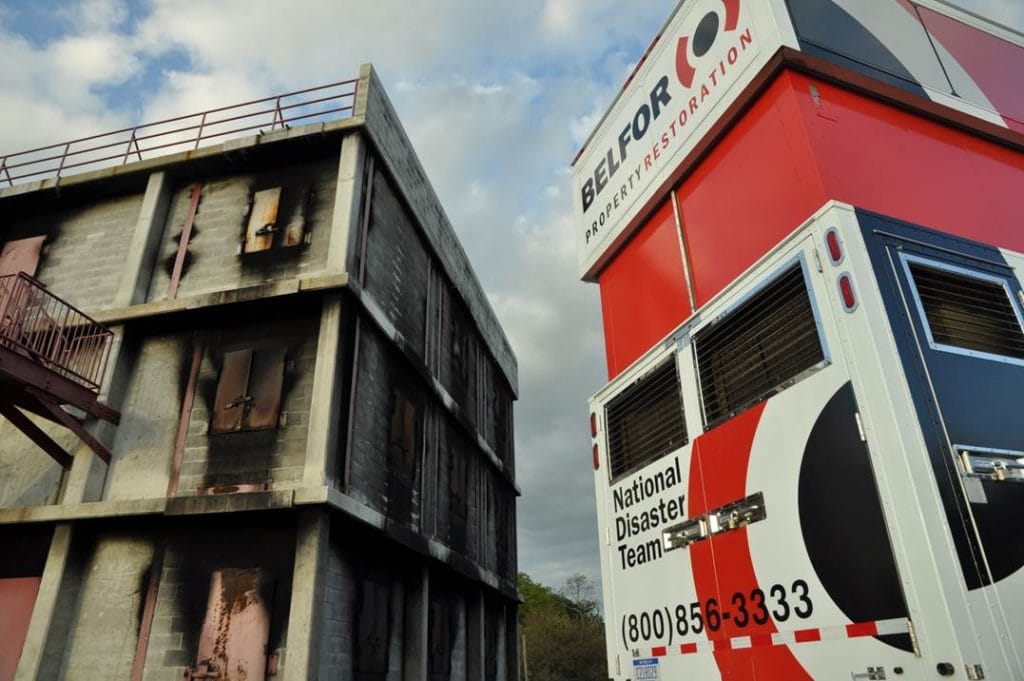 A Belfor truck next to a building damaged by fire