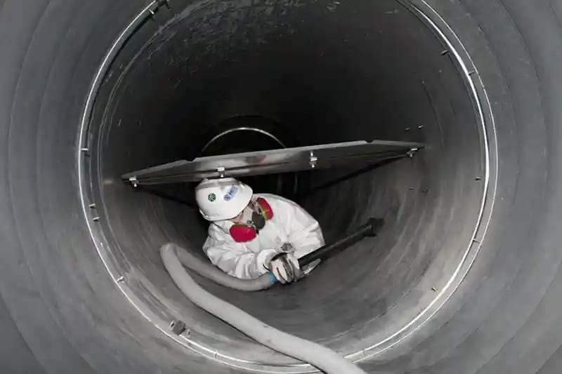 An exepert cleaning an HVAC duct